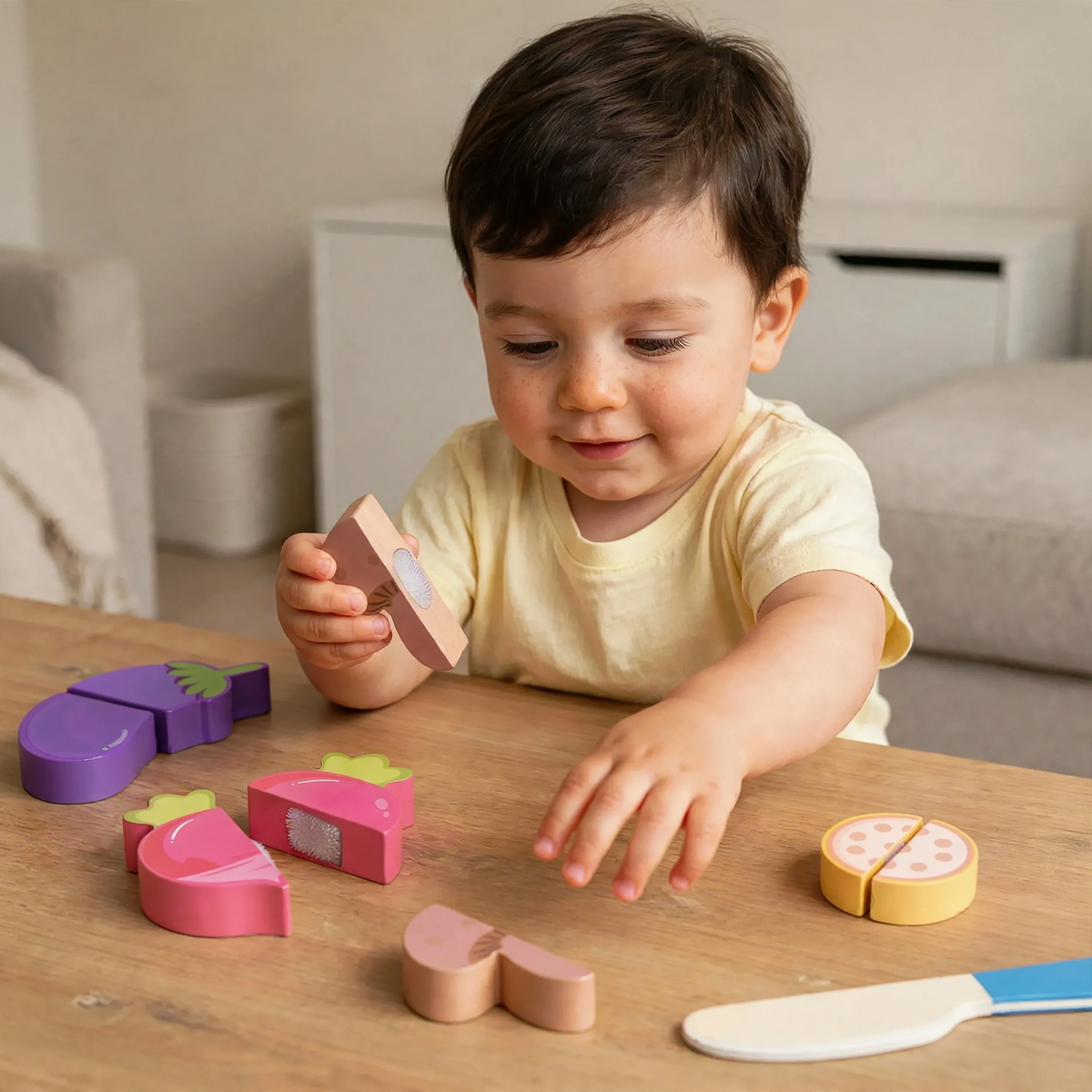 Toddler holding half of a wooden mushroom and reaching for another piece 