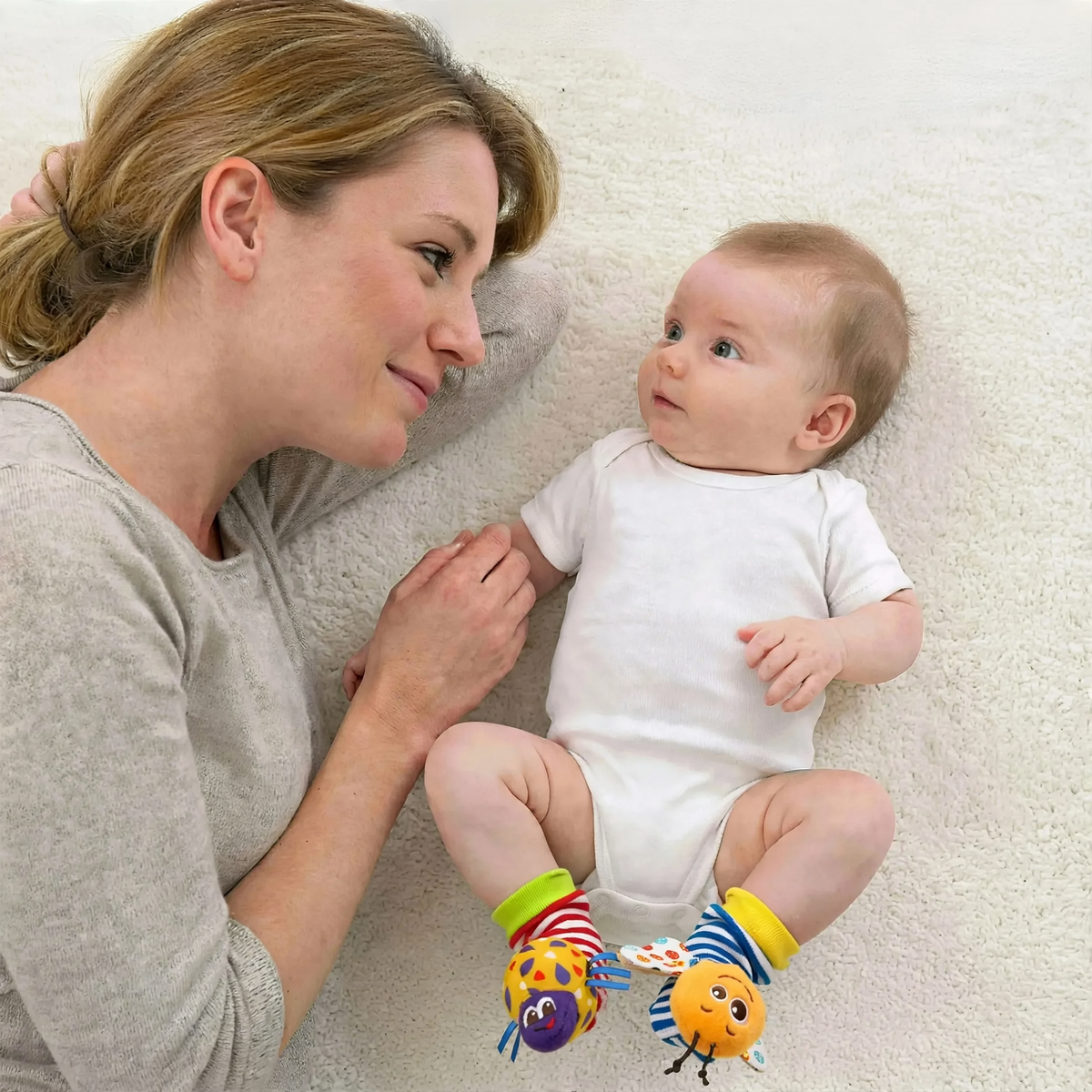 Baby wearing wrist and foot rattles and discovering their own movements 